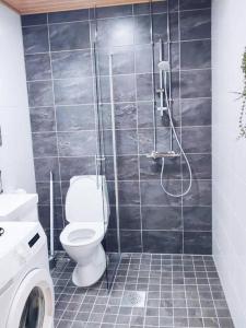 a bathroom with a shower with a toilet in it at New Studio Wave near Airport in Vantaa