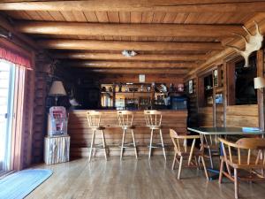 a bar with chairs and a table in a room at Unity Sky Lodge in Jackman