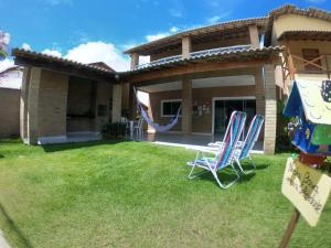a yard with two lawn chairs and a swing at Solar Leão Beach in Luis Correia