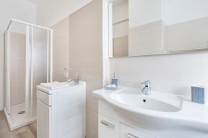 biała łazienka z umywalką i prysznicem w obiekcie Regina Luxury Flat w Rzymie