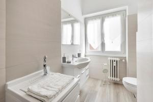 biała łazienka z umywalką i toaletą w obiekcie Regina Luxury Flat w Rzymie +16 zdjęć