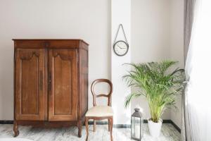 a chair in a room with a cabinet and a clock at Regina Luxury Flat in Rome