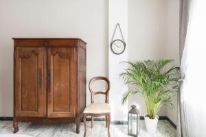 krzesło w pokoju z szafką i zegarem w obiekcie Regina Luxury Flat w Rzymie