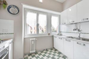 a white kitchen with a window and a radiator at Regina Luxury Flat in Rome