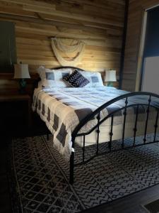 1 dormitorio con 1 cama con pared de madera en Bourbon Barrel Cottages #2 of 5 on Kentucky trail en Lawrenceburg