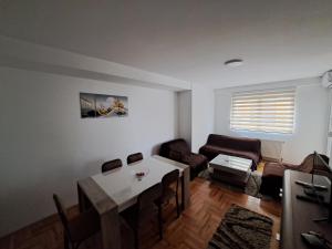 een woonkamer met een tafel en een bank bij Apartman Vranje in Vranje