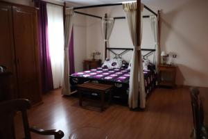 a bedroom with a canopy bed and a wooden floor at Hotel Venta El Molino in Alcazar de San Juan