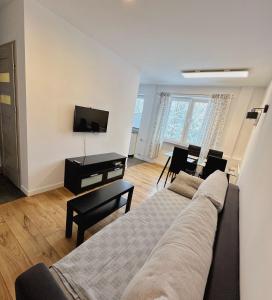 uma sala de estar com um sofá e uma televisão de ecrã plano em Apartament Gallusa em Katowice