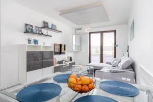 uma sala de estar branca com uma mesa de vidro e detalhes em azul em Chill Apartment - Ludwika Rydygiera em Cracóvia