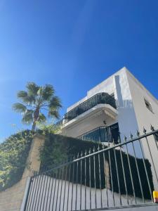 un edificio con una valla y una palmera en Apartamento Carihuela a 300 metros playa, en Torremolinos