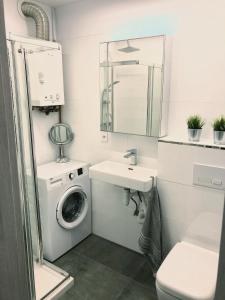 a bathroom with a washing machine and a sink at Apartament Gallusa in Katowice
