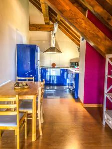 a kitchen with a wooden table and a blue refrigerator at IKUILU Ochagavia-Selva de Irati in Ochagavía