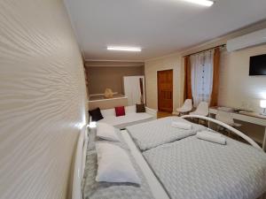 Postel nebo postele na pokoji v ubytování Árkád Apartmanház Szeged