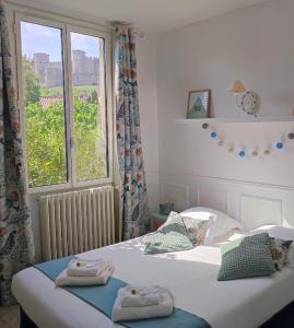 2 camas individuales en un dormitorio con ventana en La Villa Carcassonne, Cité 8 min à pieds, Clim, Piscine, Full Wifi, Borne 7,5kW, Vélo élect, Parking privé, en Carcassonne