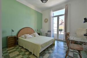 um quarto com uma cama, uma mesa e uma janela em Spacieux et lumineux, idéal T4 en centre ville em Perpignan