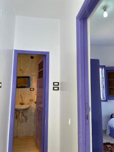 a blue door leading to a bathroom with a sink at Ghalia Guest House in Aswan