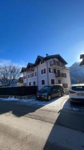 two cars parked in front of a white house at Al Bel VEDER in Levico Terme