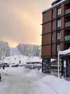 a snow covered ski slope next to a building at Woodside Residences & SPA in Kopaonik