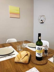 eine Flasche Wein und ein Laib Brot auf dem Tisch in der Unterkunft Le Bokeh - Face à la Cité Médiévale in Carcassonne