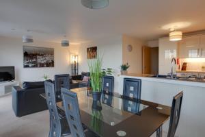 a kitchen and living room with a glass table and chairs at Niche Water Tower Apartments in Braintree