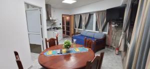 a living room with a table and a blue couch at Look Departamentos in Carhué
