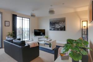 a living room with a couch and a tv at Niche Water Tower Apartments in Braintree