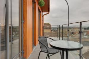 a table and chair on a balcony with a view at Niche Water Tower Apartments in Braintree
