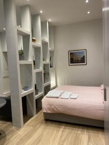 1 dormitorio con cama y estanterías blancas en #milanodabere Urban Loft, en Milán