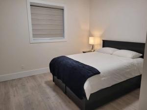 a bedroom with a large bed and a window at Spacious getaway for couples with separate entrance in Surrey