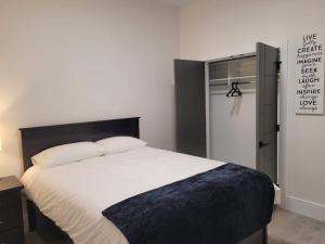 a bedroom with a bed and a door with a sign at Spacious getaway for couples with separate entrance in Surrey