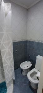 a bathroom with a toilet and a sink at Look Departamentos in Carhué +21 photos