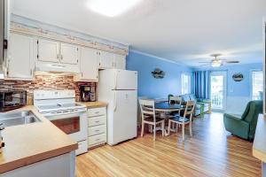 a kitchen with white appliances and a table with chairs at Seaspray 134 in Atlantic Beach