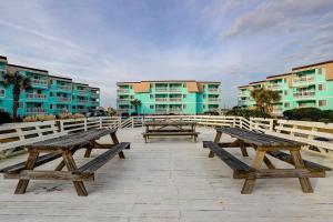 a group of picnic tables in front of some buildings at Seaspray 134 in Atlantic Beach