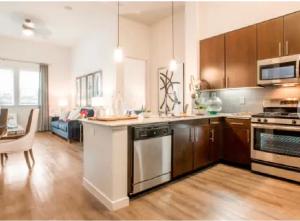 una cocina con armarios de madera y una mesa en una habitación en A-Class Luxury 2 Bedrooms Apt in Woodland Hills CA, en Los Ángeles