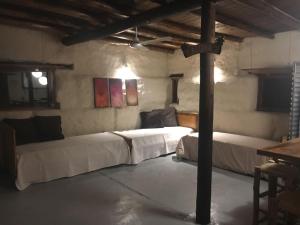 1 dormitorio con 2 camas en una habitación con un poste en Tierra de Leones en Rodeo