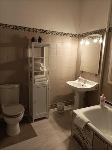 a bathroom with a toilet and a sink and a tub at La Boussole - Maison meublée 3 chambres 6 pers. in Chinon