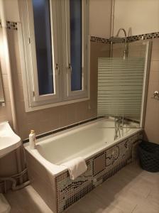 La salle de bains est pourvue d'une baignoire et d'un lavabo. dans l'établissement La Boussole - Maison meublée 3 chambres 6 pers., à Chinon