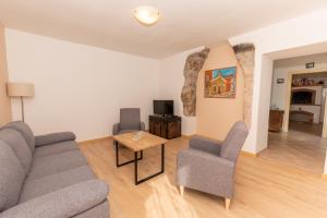 een woonkamer met een bank, 2 stoelen en een tafel bij Haus Gaia in Labin
