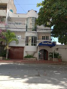 un gran edificio blanco con toldo azul en una calle en HOSTAL PARMA, en Santa Marta