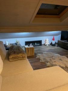 uma sala de estar com um sofá e uma lareira em Attico con vista AltopianoAsiago em Roana