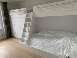 - un lit superposé blanc avec une échelle dans une chambre dans l'établissement Beautiful penthouse at 5min of Albert place, à Knokke-Heist