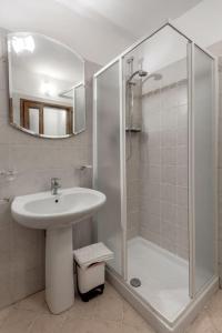 La salle de bains est pourvue d'un lavabo et d'une douche avec un miroir. dans l'établissement Loft Ortensia garden WiFi air conditioning, à Florence