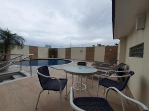 balcón con mesa, sillas y piscina en Apartamento Centro Manaus Hotel Saint Paul - 5º Andar - Apto 1055, en Manaus