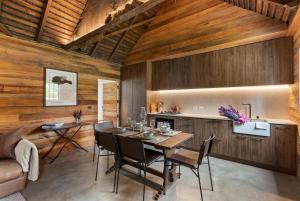 a dining room with wooden walls and a table and chairs at Historical Hicks Cottage in Queenstown