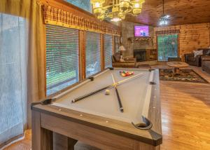 a pool table in the middle of a living room at Real Log Cabin With Amazing Views, Hot Tub, Sauna, Games in Gatlinburg