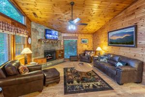 a living room with leather furniture and a fireplace at Real Log Cabin With Amazing Views, Hot Tub, Sauna, Games in Gatlinburg