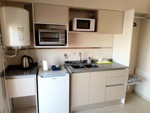 a small kitchen with a white refrigerator and microwave at Apart del Centro 02 cochera opcional in Santa Fe