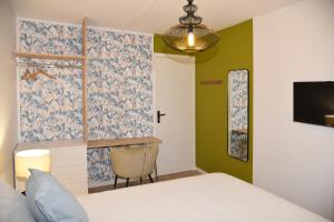 1 dormitorio con 1 cama y TV en la pared en Les Chambres de Troyes - Parking Free Fibre Netflix, en Troyes