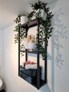 uma prateleira preta com plantas na parede em Home from Home Slough em Slough