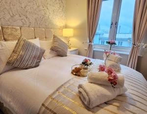 a bedroom with a bed with towels and a window at Home from Home Slough in Slough